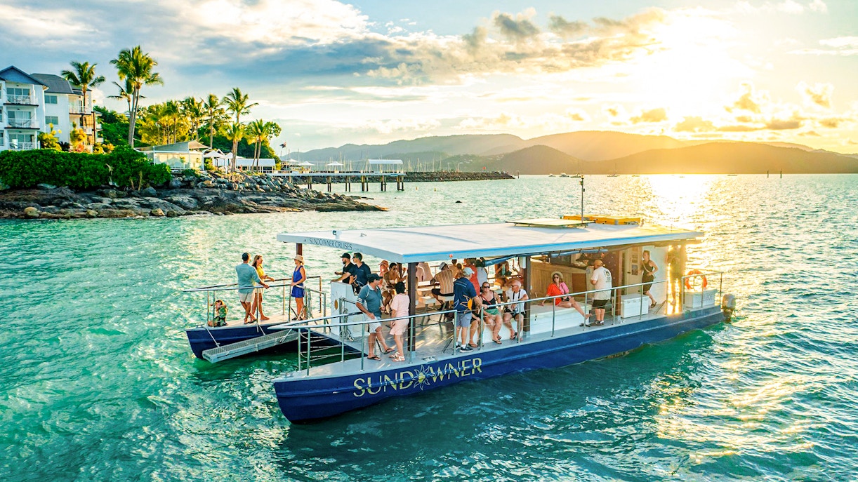 Sundowner cruise with people enjoying sunset near Airlie Beach.