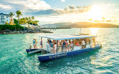 Sundowner cruise with people enjoying sunset near Airlie Beach.