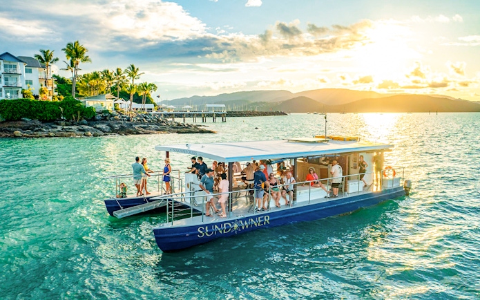 Sundowner cruise with people enjoying sunset near Airlie Beach.
