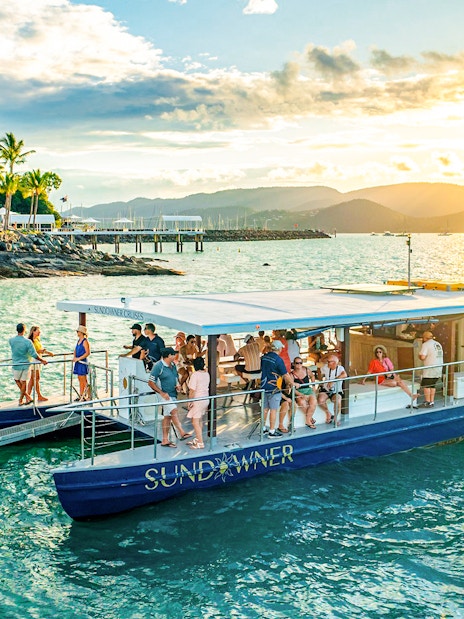 Sundowner cruise with people enjoying sunset near Airlie Beach.