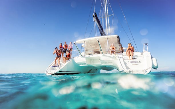 Catamaran with tourists in life vests on Isla Mujeres tour.