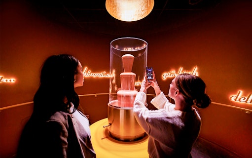Tourists photographing chocolate fountain at Chocoversum, Hamburg.