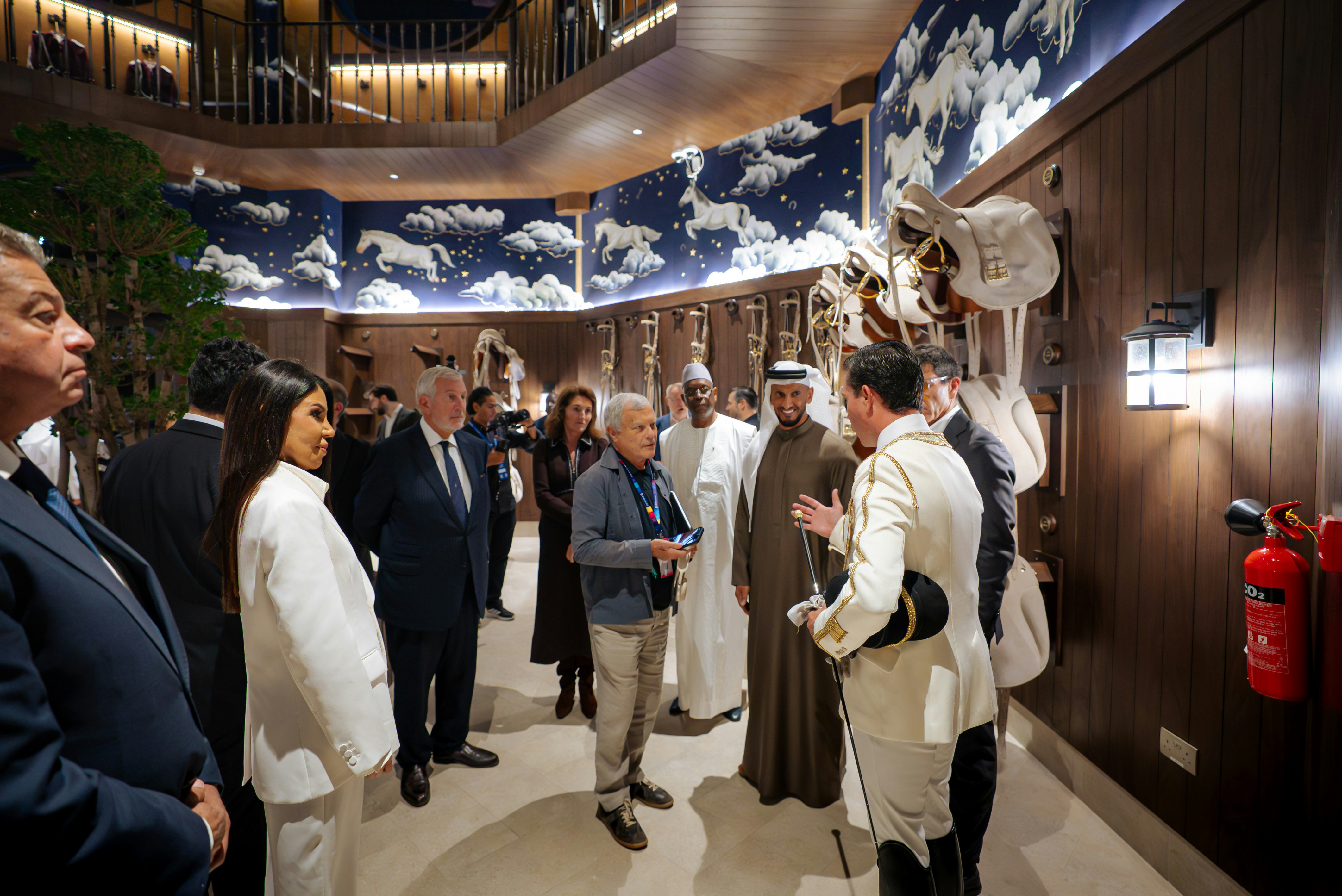 Group touring Abu Dhabi Royal Equestrian Arts venue with equestrian decor.