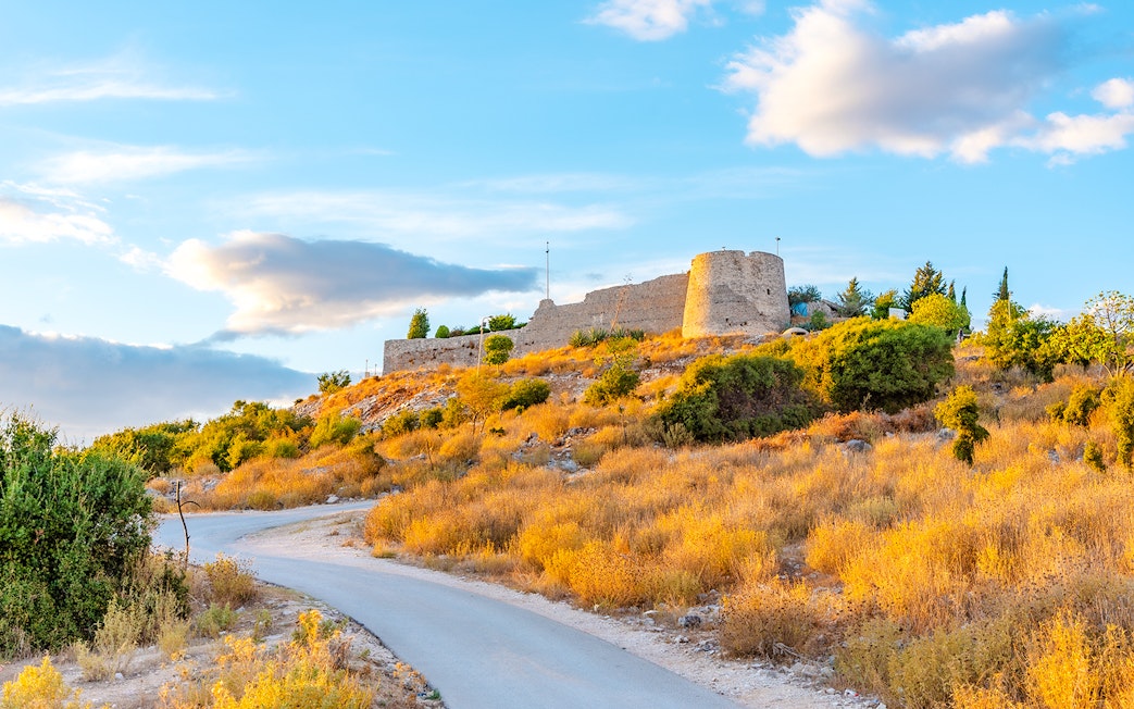 Sunset view of Lekuresi Castle on a hill in Sarande, Albania.