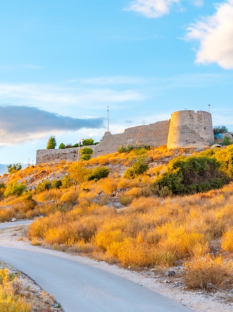 Sunset view of Lekuresi Castle on a hill in Sarande, Albania.