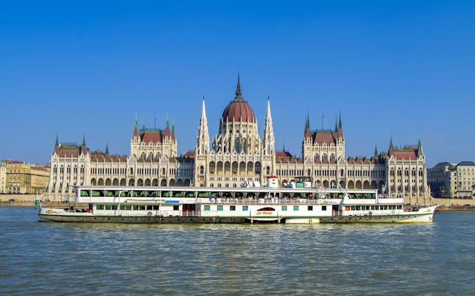 Cruise boat on the Danube River with Budapest Parliament in the background.