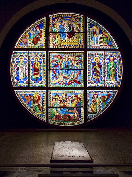 Stained glass window and statues inside Museo dell'Opera Siena