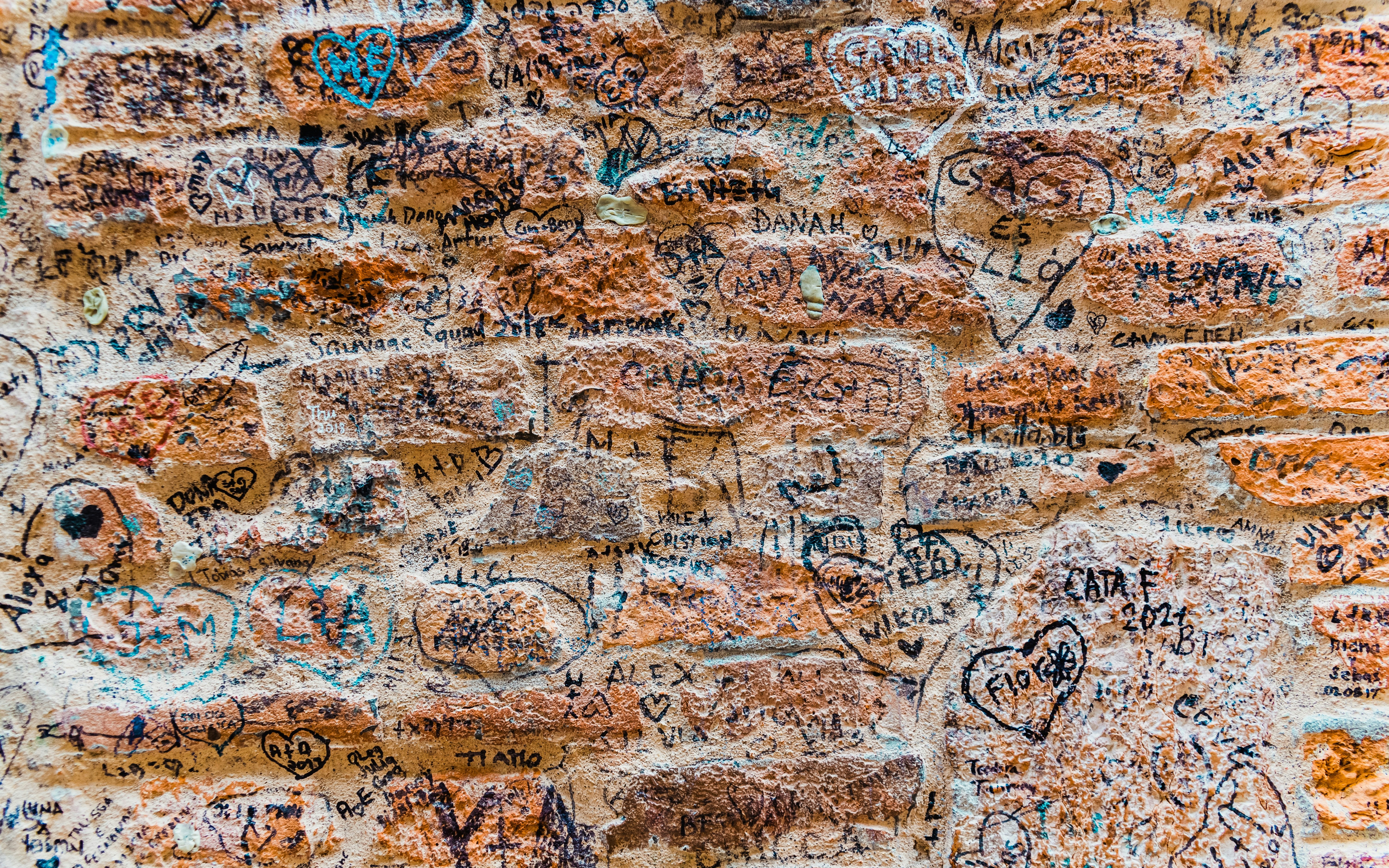 Graffiti-covered stone wall near Juliet's house in Verona, Italy.