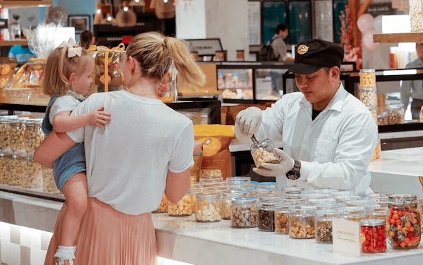 Customer sampling snacks at Depachika food hall, View at the Palm.