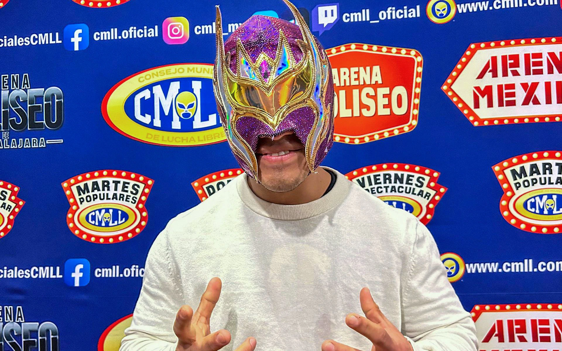 Luchador in colorful mask at Arena Mexico Lucha Libre event backdrop.