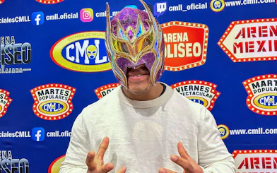 Luchador in colorful mask at Arena Mexico Lucha Libre event backdrop.