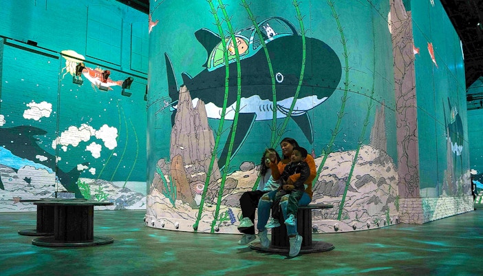 Visitors exploring Fabrique des Lumières' Tintin immersive adventure in Amsterdam.