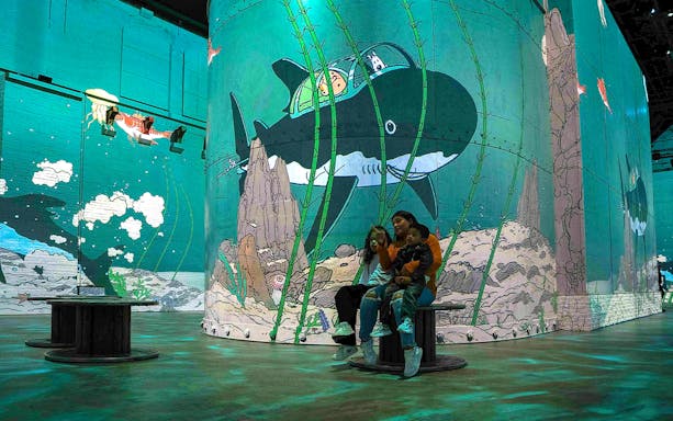 Guests viewing animated underwater art at Fabrique des Lumières.