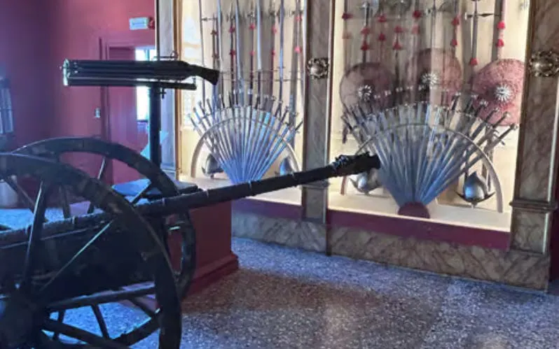 Historic weaponry display at Doge's Palace, Venice, featuring swords and shields.