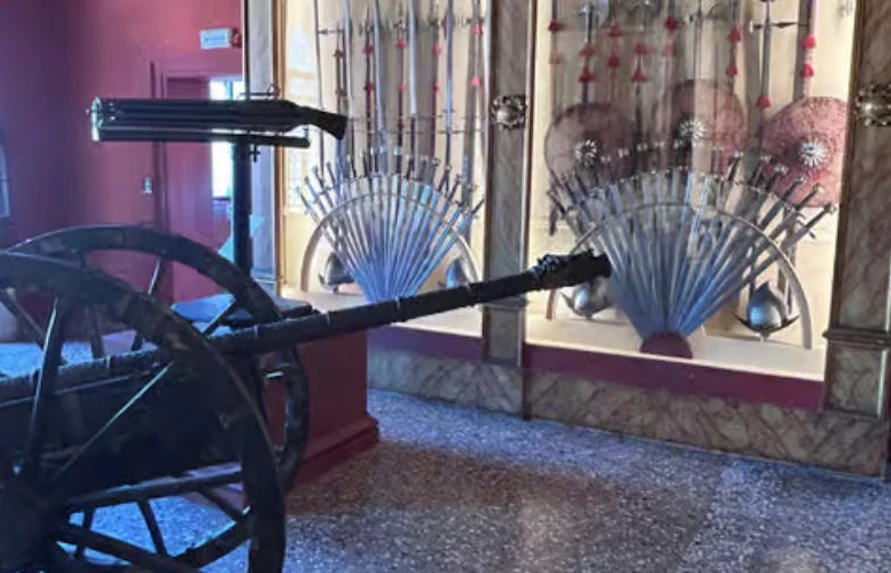 Historic weaponry display at Doge's Palace, Venice, featuring swords and shields.
