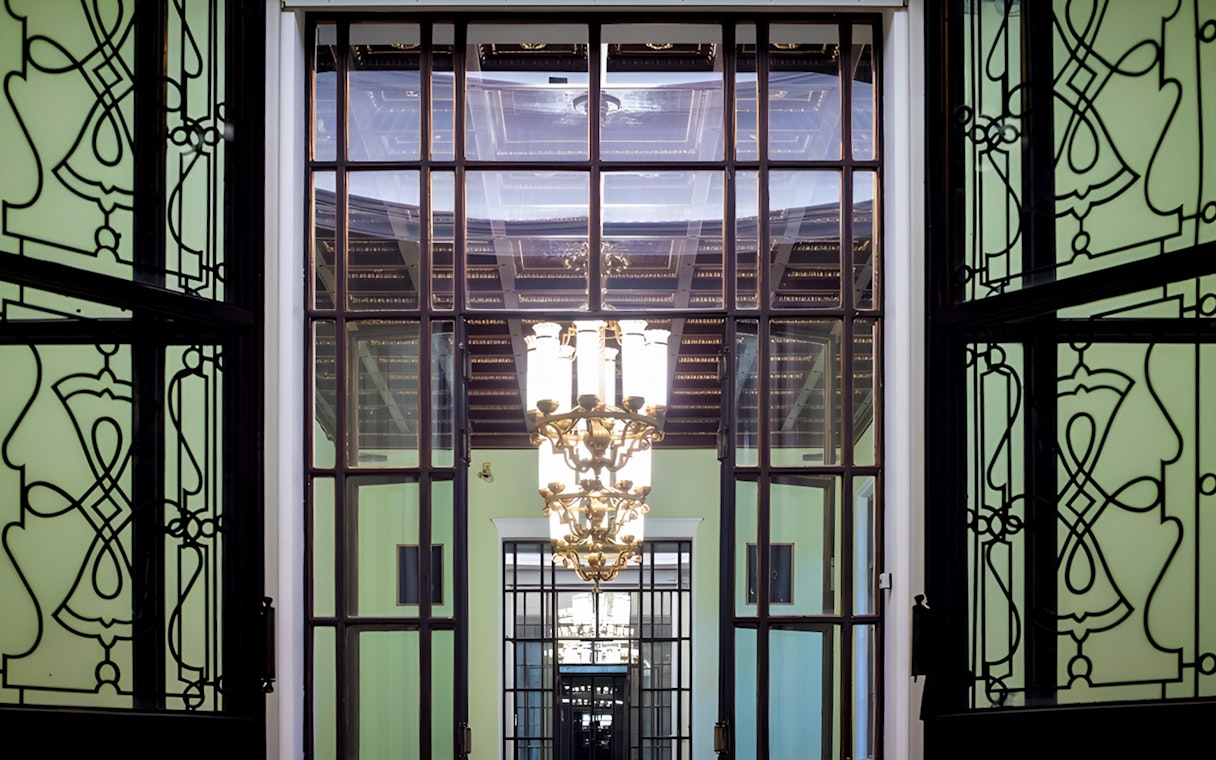 Palace of Culture and Science interior with ornate chandelier and decorative glass doors.