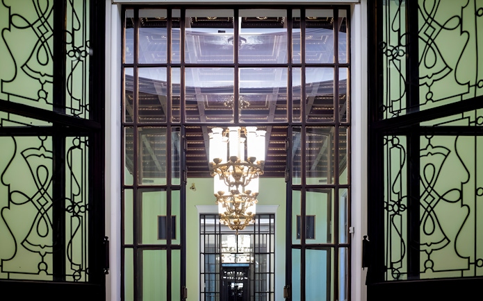 Palace of Culture and Science interior with ornate chandelier and decorative glass doors.