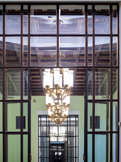 Palace of Culture and Science interior with ornate chandelier and decorative glass doors.