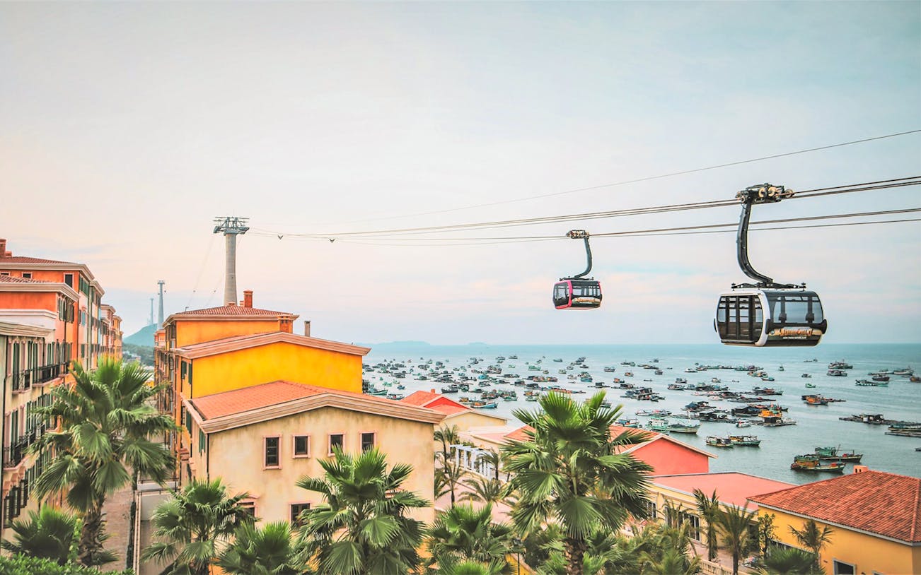 Cable cars over coastal town with boats, Red River Tours 3 Island Hopping.