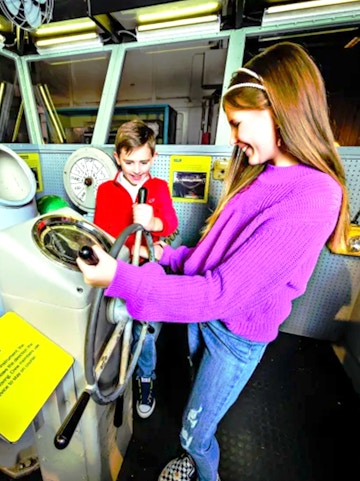 Children exploring ship controls at the Intrepid Museum, New York.