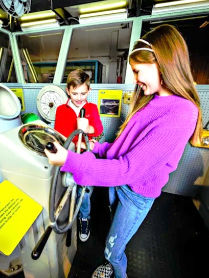 Children exploring ship controls at the Intrepid Museum, New York.