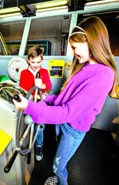 Children exploring ship controls at the Intrepid Museum, New York.