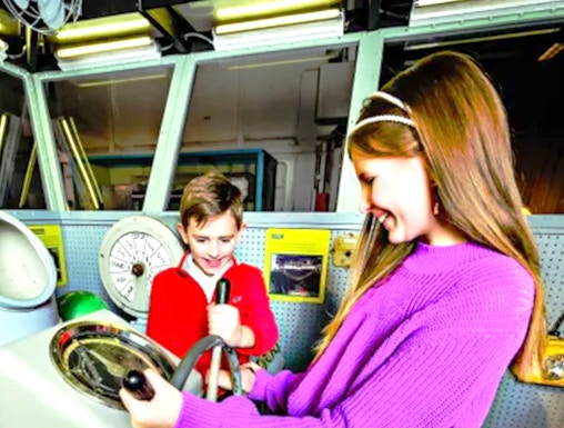 Children exploring ship controls at the Intrepid Museum, New York.