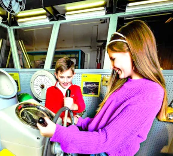 Children exploring ship controls at the Intrepid Museum, New York.