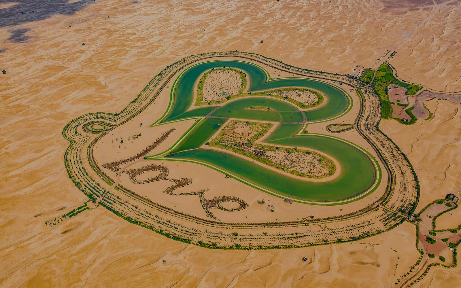 Heart-shaped lakes in Al Qudra Desert, Dubai, surrounded by sand dunes.