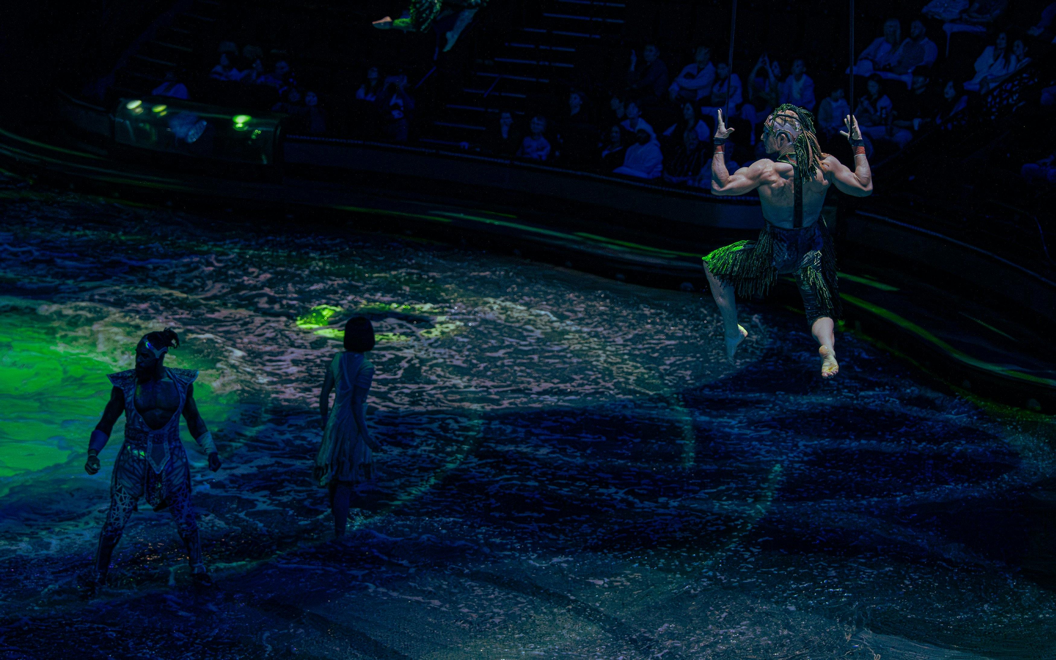 Performer swinging above water during La Perle show in Dubai.