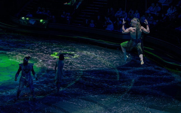 Performer swinging above water during La Perle show in Dubai.