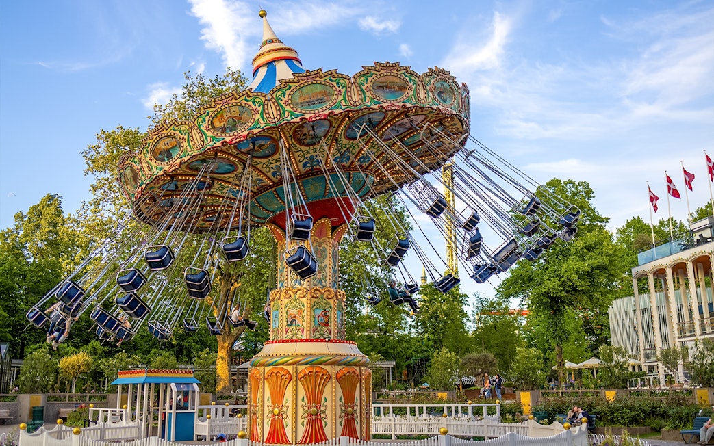 Swing ride at Tivoli Gardens, Copenhagen, with colorful seats and ornate design.