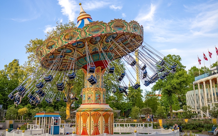 Swing ride at Tivoli Gardens, Copenhagen, with colorful seats and ornate design.
