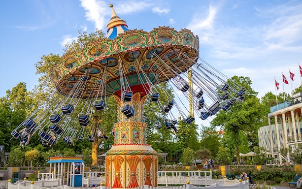 Swing ride at Tivoli Gardens, Copenhagen, with colorful seats and ornate design.