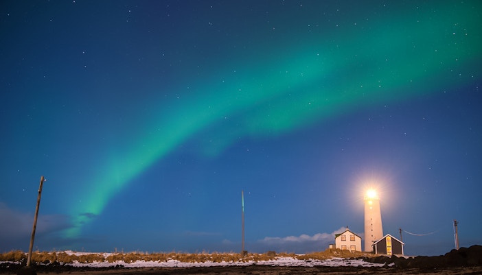Grótta Lighthouse in Reykjavik with Northern Lights in the sky.