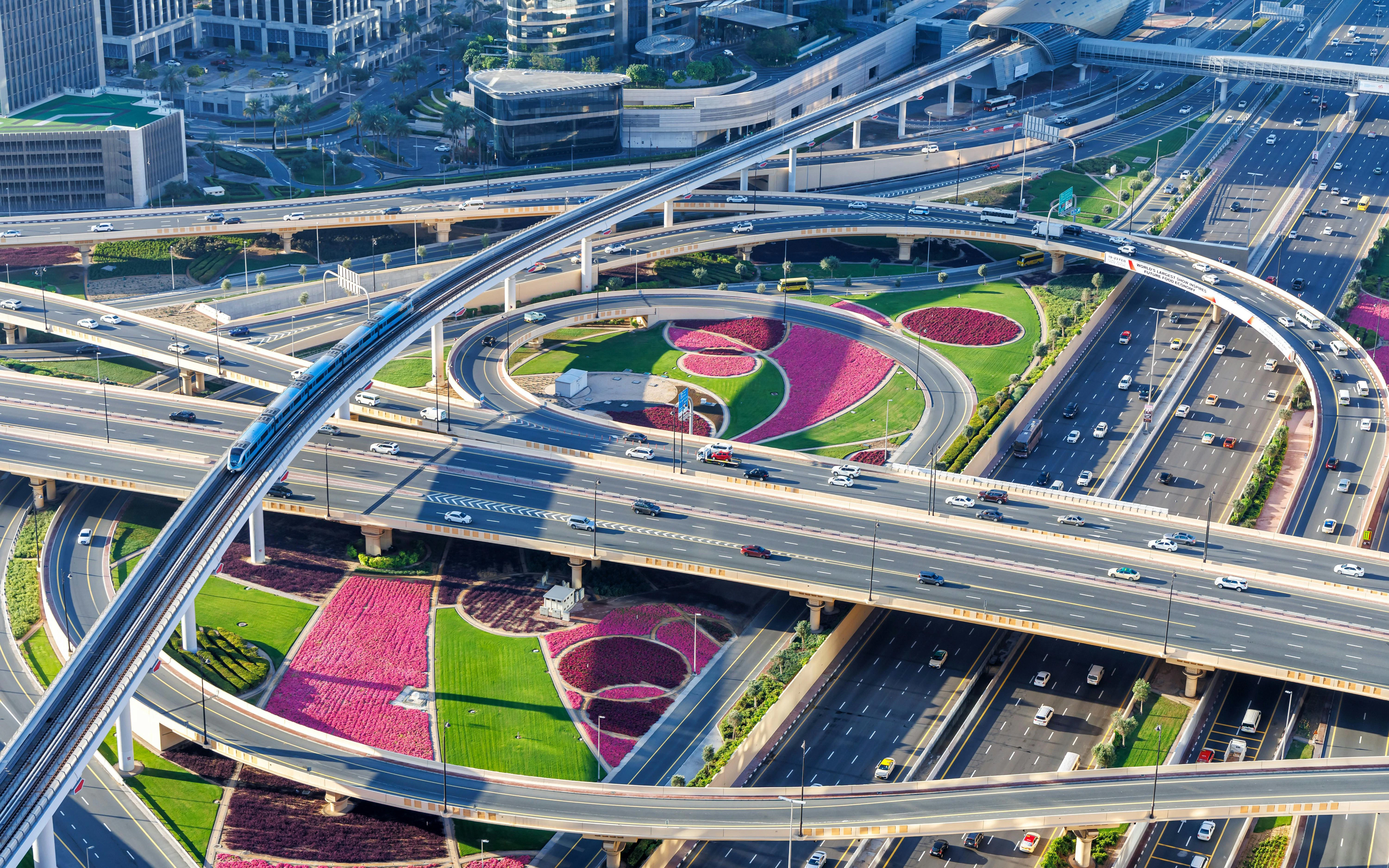 Dubai Sheikh Zayed Road interchange with metro and traffic near Burj Khalifa.