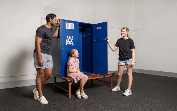 Visitors exploring Melbourne Cricket Ground locker room during tour.