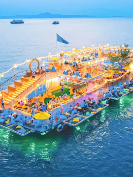 Tappia Floating Cafe with guests dining on a lit-up platform over the water.