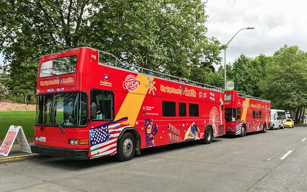 Seattle hop-on hop-off sightseeing bus parked on a tree-lined street.