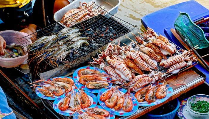 Seafood being prepared on a boat at a floating market in Bangkok, Thailand.