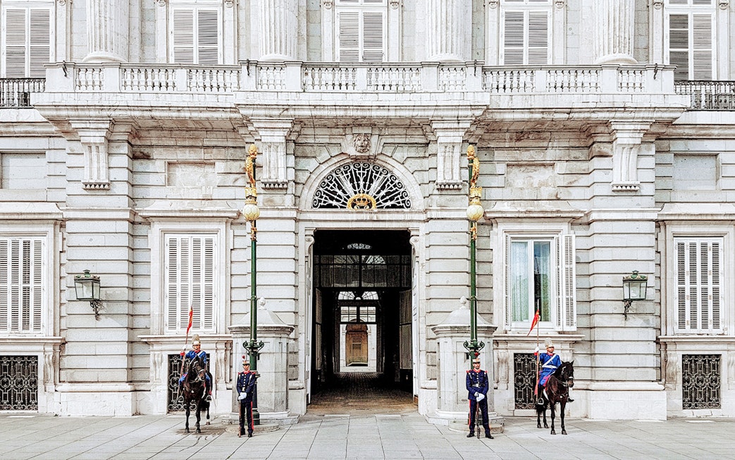 Guards at the entrance of the Royal Palace of Madrid during a guided tour.