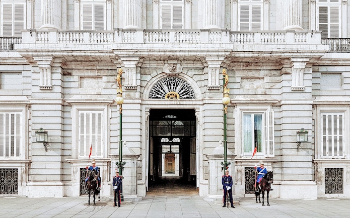 Guards at the entrance of the Royal Palace of Madrid during a guided tour.