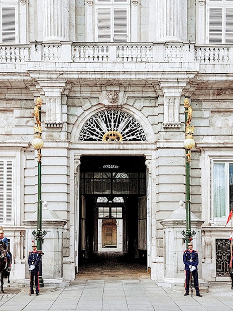 Guards at the entrance of the Royal Palace of Madrid during a guided tour.