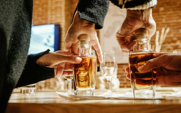 Hands holding bottles during Casa Martini guided tour tasting experience.