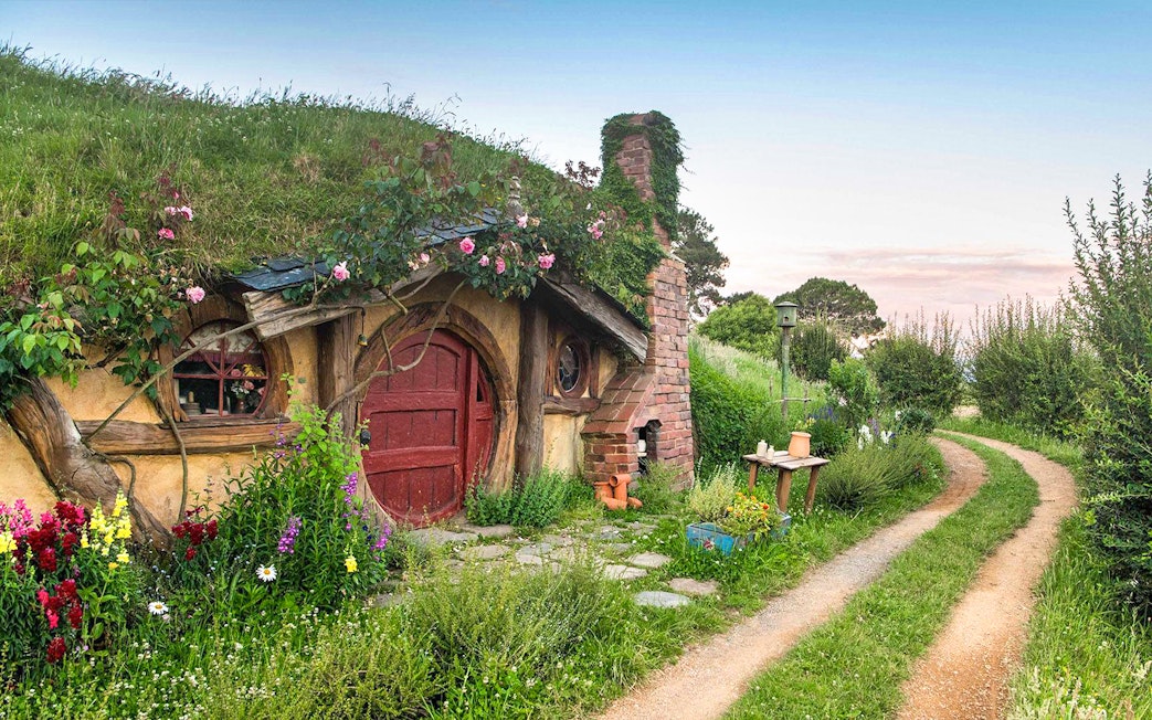 Hobbiton Movie Set house with round door and garden path in New Zealand.