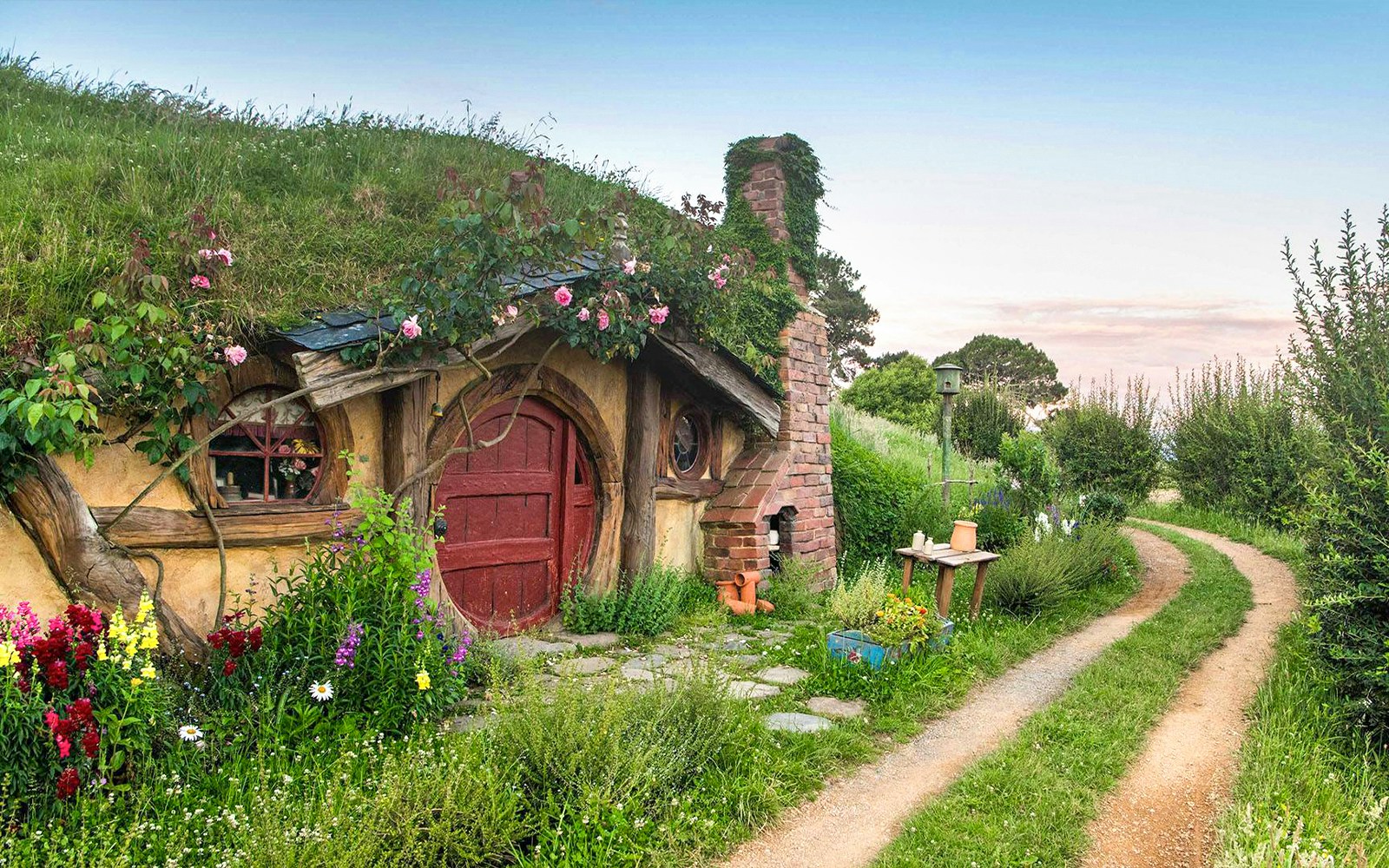 Hobbiton Movie Set house with round door and garden path in New Zealand.
