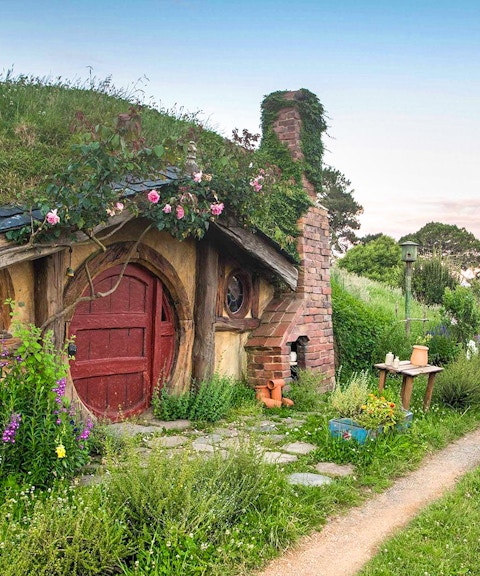 Hobbiton Movie Set house with round door and garden path in New Zealand.