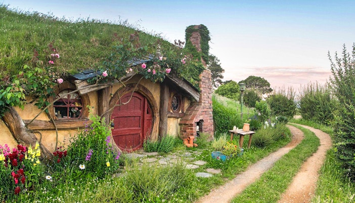 Hobbiton Movie Set house with round door and garden path in New Zealand.