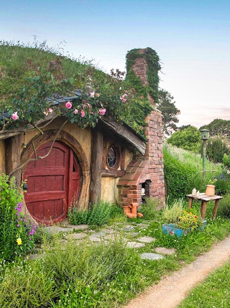 Hobbiton Movie Set house with round door and garden path in New Zealand.