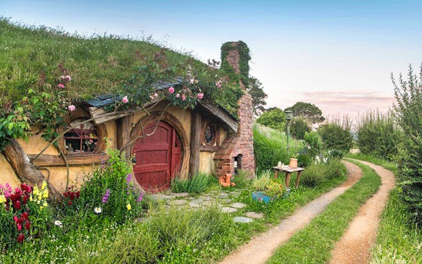 Hobbiton Movie Set house with round door and garden path in New Zealand.